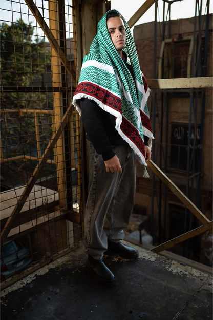 Person wearing a green and red patterned shawl in an industrial setting